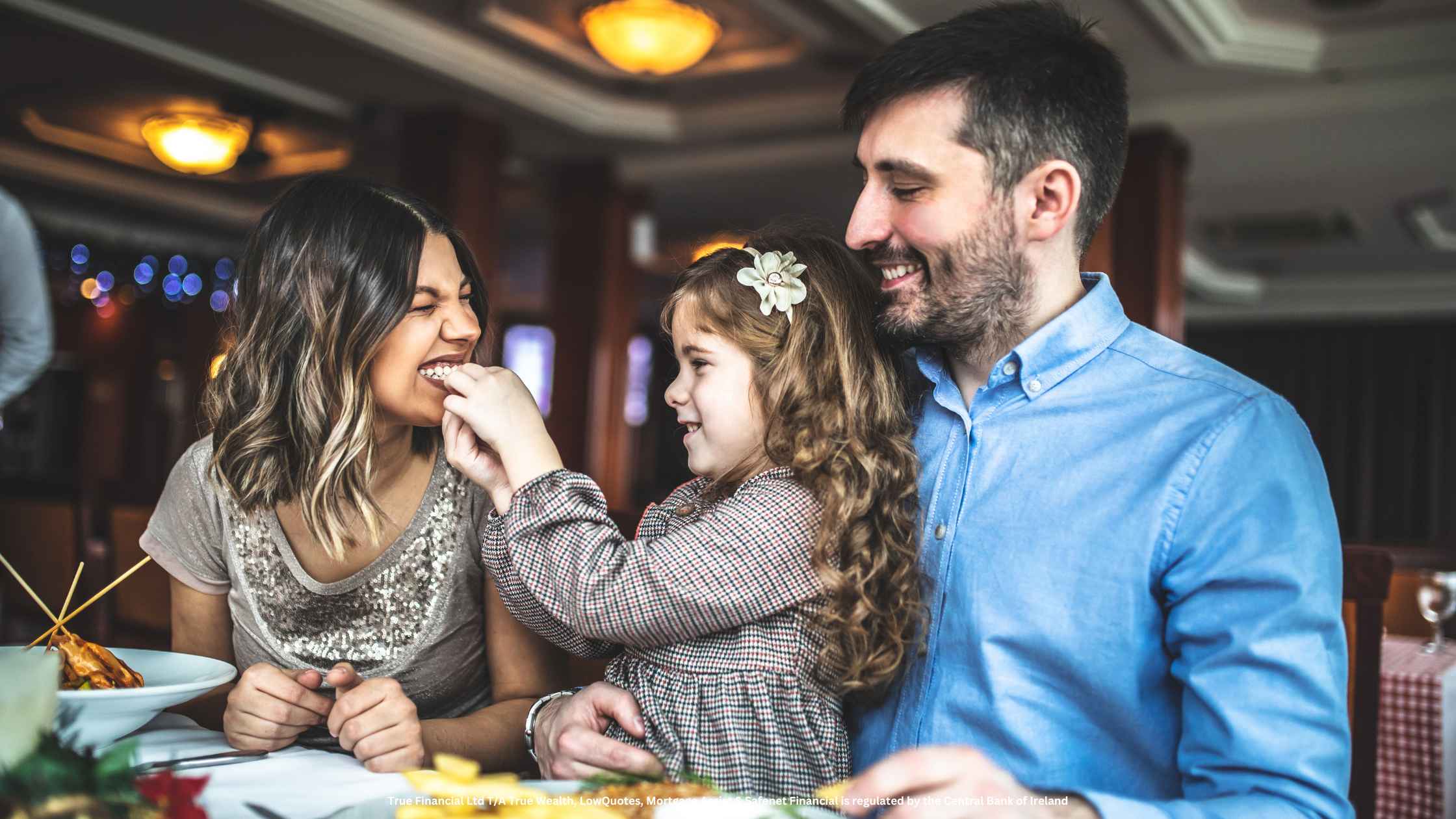 father and mother in a restaurant with their child